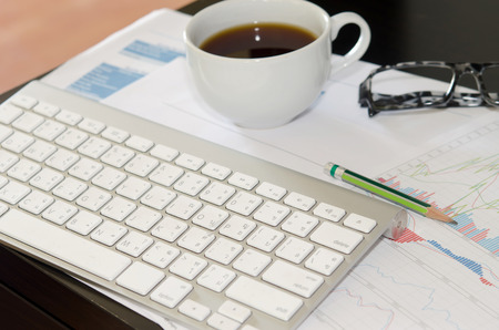 Modern business workplace with tablet, graphs and charts on a desktop.の写真素材