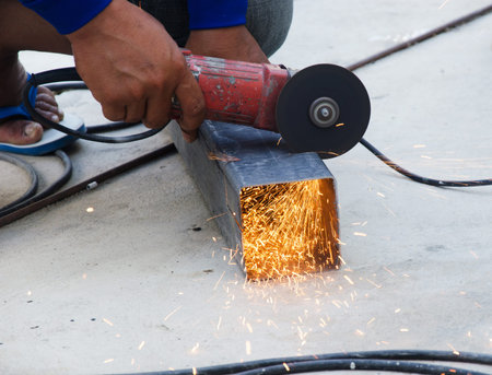 Electric wheel grinding on steel structure in factory
