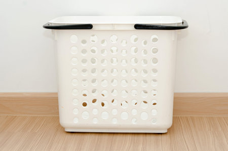 white basket on floor in room.