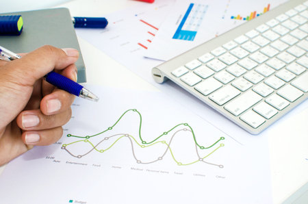 Businessman analyzing investment charts with keyboard.