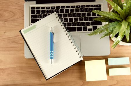 Office table with notepad, computer and suppliesの写真素材