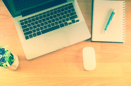 Book and laptop on a wooden table. Vintage toneの写真素材