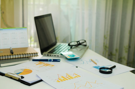 business documents and computer with charts growth