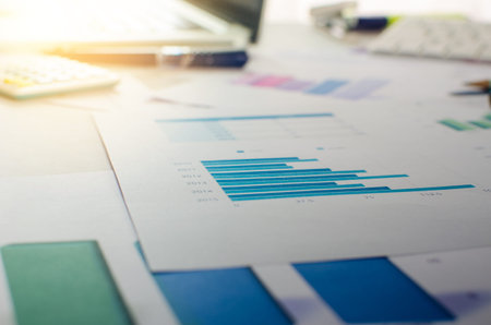 Analysing a business graph with a calculator and pen on desk.