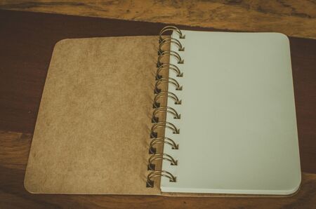 Old notebook on wooden background. Vintage Filterの写真素材