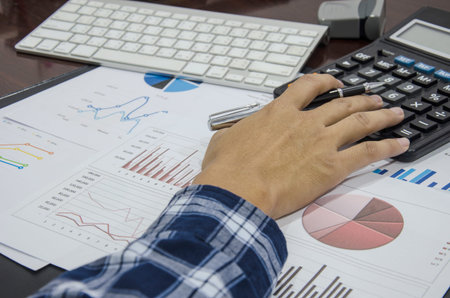 Business documents on table with keyboard computer and graph financial diagram.