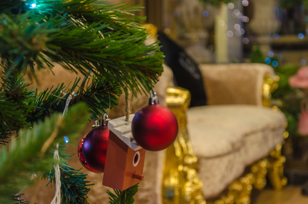 red bauble hanging from a decorated Christmas tree.の写真素材