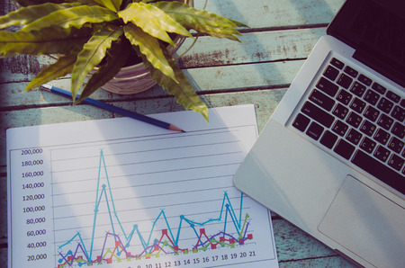 Laptops and graphs with a  pencil on a  wood table. Tone vintageの写真素材