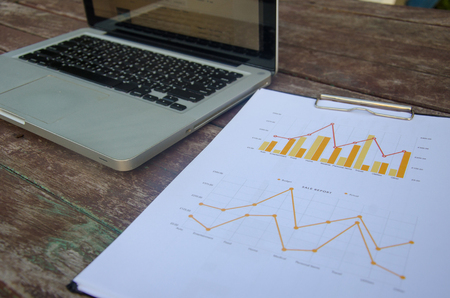 Financial chart with computer laptops on table woods.の写真素材