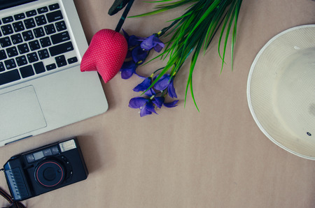 Flower camera and hat with lap top on brown background.の写真素材
