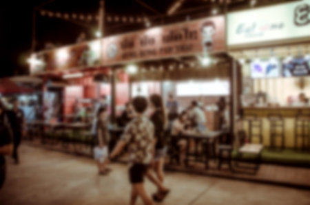 Blurred people walking in the night market.