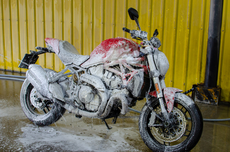 Red motorcycle washed with foam.の写真素材