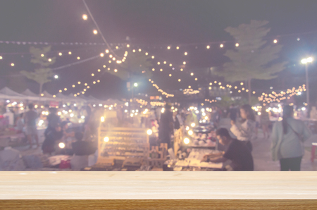 wood table top and Abstract Blurred Festival food night market. Can be used for display or montage your products.の写真素材