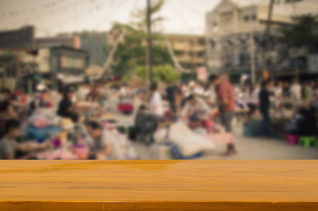 wood top table and Abstract Blurred image of people at market on street.Can be used for display or montage your products.の写真素材