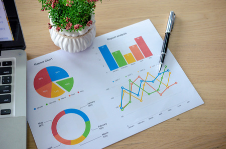 business graphs reports, pen and computer laptop  on the table.の写真素材
