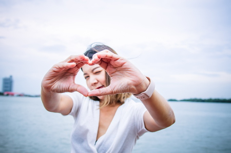 Beautiful Happy Woman Holding Heart Shaped Hands.の写真素材