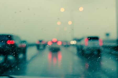 blur car on the road in trafic jam with raindropの写真素材