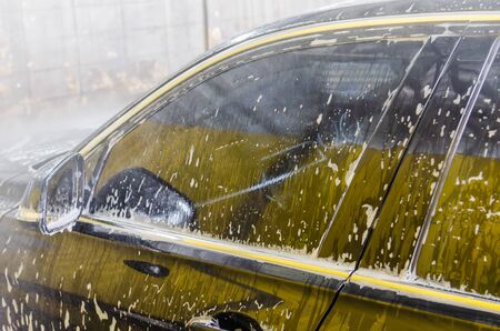 Wash the car with foam at the car wash station.の写真素材