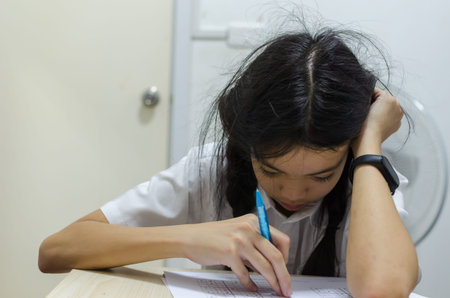 A young asian schoolgirl sitting in a stressful room from homework