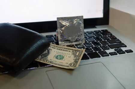Condoms, dollar banks and notebooks. Buy sex services onlineの写真素材