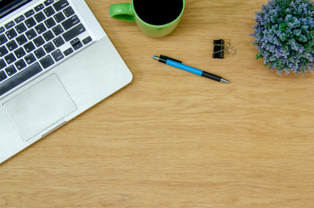 Top view laptop computer , coffee cup , flower and pen on wood table.Flat lay  copy spce.work for...