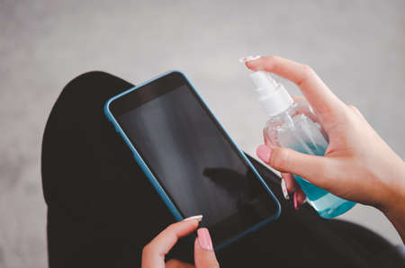 Spray to disinfect mobile phone with alcohol. concept of health care to prevent diseaseの写真素材
