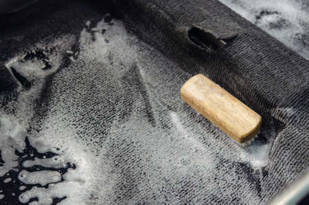Wash the car carpet.Detailing on interior of modern car.Clean by using a brush and cleaning solution on the car carpet.の写真素材