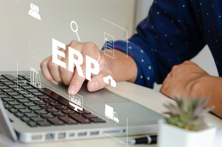 Enterprise Resource Planning (ERP) Software system for business resource plans. concept hand typing computer laptop icons on virtual screen.の写真素材