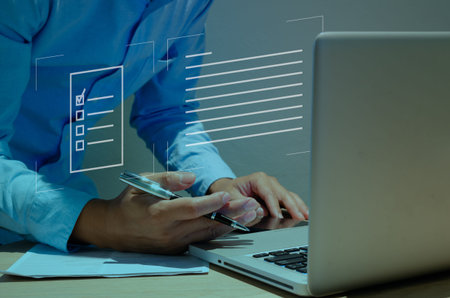 Hand holding pen on laptop with online accounting system concept. Icons document business on virtual...