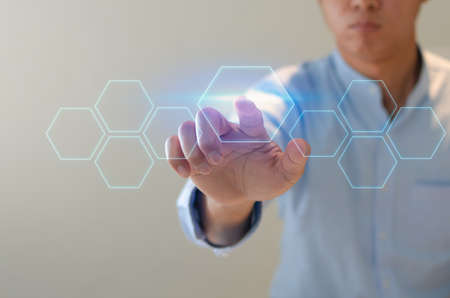 man points to a futuristic interface. On a virtual screen, a businessman presses a button. concept for a business There is space for text.の写真素材