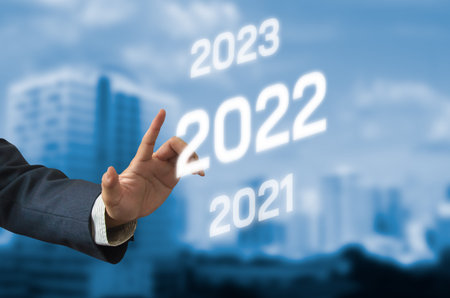 hand hold pen touching screen digital virtual futuristic interface 2022 New year candlestick graph...
