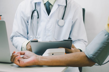 doctor measures the blood pressure of an elderly male patient.