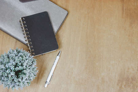 Top view flat lay notebook and flower and pen on wood table.Copy spaceの写真素材