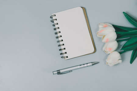 Top view flat lay notebook and flower and pen on table.Copy spaceの写真素材