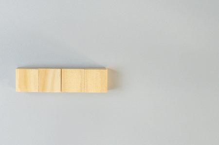 Blank wooden cubes for icons or symbols on gray background.