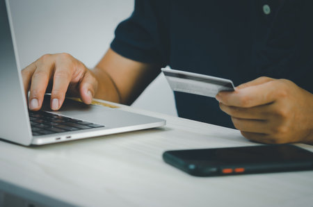 male hands on computer keyboard doing financial and credit card transactions or online shopping on the Internet.の写真素材