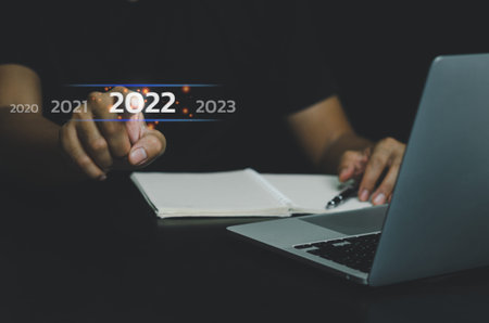 Businessman hand touching 2022 year number on virtual screen concept digital trends industry and...