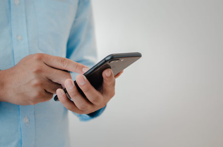 close up man hand holding mobile smartphone copy space.person texting text message internet...
