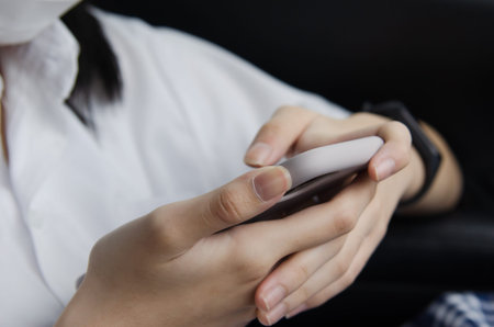 close up woman hand holding a mobile phone in the car cabin.