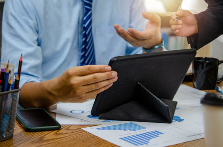 Business people meeting at the office by analyzing data from financial graphs and investment charts...