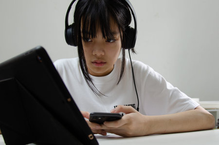 girl wearing headphones studying online with computer laptop and listen to relaxing music or play...