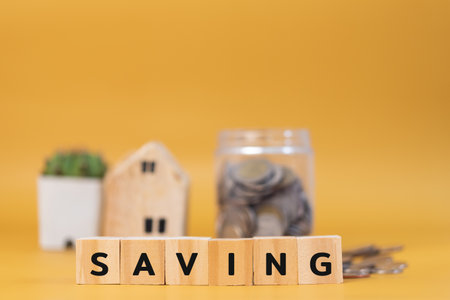 wood cube block saving on yellow background.Business finance investment economy banking concept.の写真素材