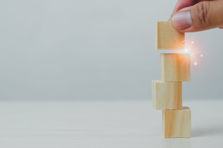 Hand wood block stacking on a table. Business growth Choose a business concept for development and...