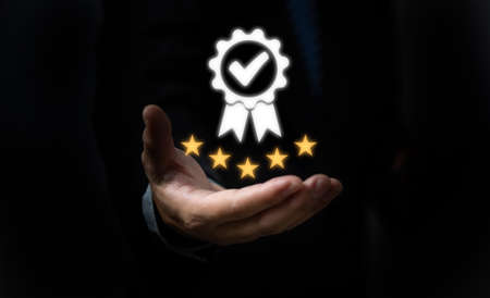 Hand shows the sign service Quality assurance 5 star, Guarantee, Standards, ISO certification and standardization concept.の写真素材