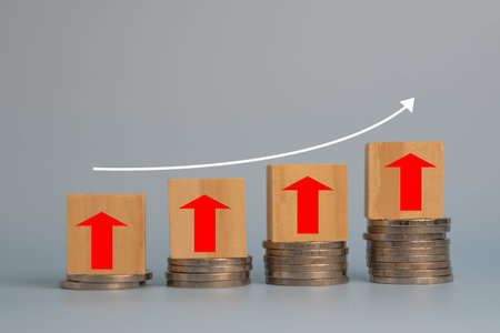 Business finance investments economy stack coin inflation and arrow red with wood cube on desk.