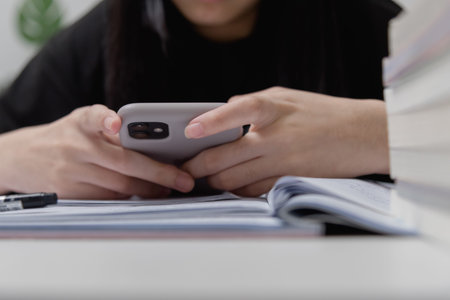 Asian young girl use a mobile smart phone to study education online at home.
