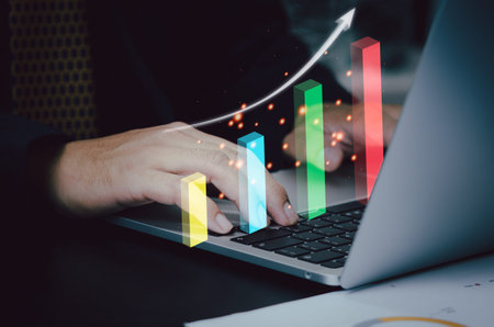 Graph and arrow virtual screen with computer laptop on desk. Business investment growth analysis...