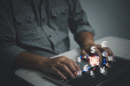 Virtual trolley shopping cart icon and currency money sign, buy on internet, e-commerce, Businessman hand typing on keyboard with online shopping concept.の写真素材