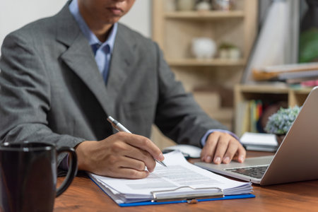 businessman signs documents with a pen making the signature on desk.の写真素材