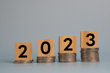 Cube wood New years 2023 start up investment new business and finance economy growth row of coins.Saving money and financial plan concept for investment in new year 2023.の写真素材